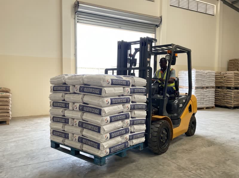Chariot élévateur soulevant une palette de sacs Sadicom au dépôt